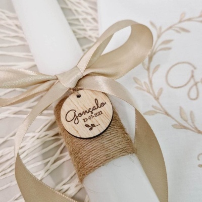 Vela decorativa branca com fita bege e pendente de madeira com texto
