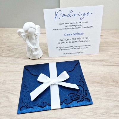 Convite de batizado com envelope azul e laço branco e figura de anjo branca.