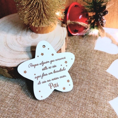 Anilha decorativa estrela branca com texto em castanho num cenário rústico e natalício