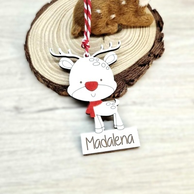 Adorno de rena branco com nariz e cachecol vermelho com nome Madalena sobre madeira