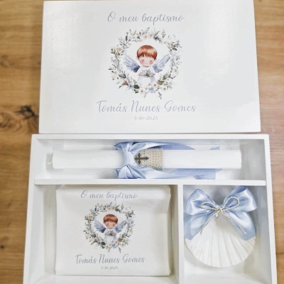 Conjunto de batismo com vela, toalha e concha com decoração de anjo e laço azul.