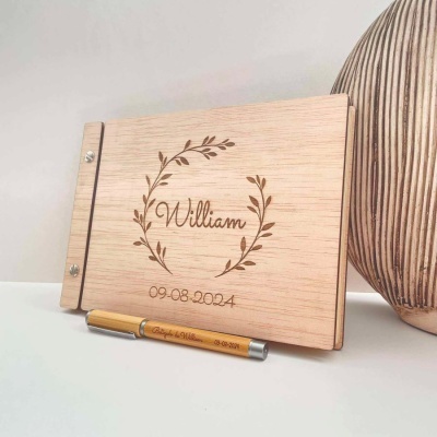 Livro de madeira personalizado com nome e data, caneta dourada gravada, vaso decorativo ao lado