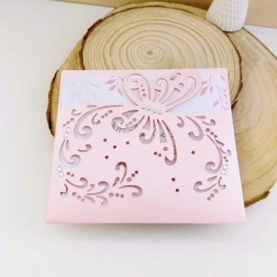 Cartão rosa com corte a laser floral e borboleta, detalhes brilhantes, sobre madeira redonda