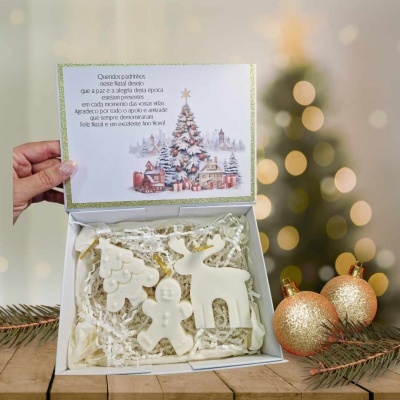 Caixa branca com ornamentos natalícios em branco e envelope decorativo com mensagem de Natal