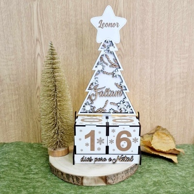 Calendário de Natal decorativo em madeira com árvore branca, nomes Leonor e Fábian, números 1 e 6, árvore dourada e folhas secas numa base de madeira
