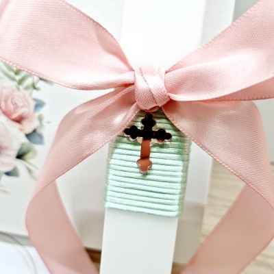 Vela branca com fita rosa e pendente de cruz
