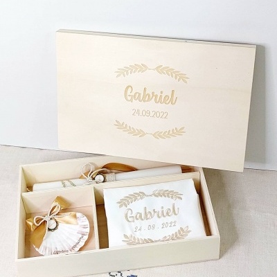 Caixa de madeira clara com nome Gabriel e data, com vela personalizada e acessórios dentro