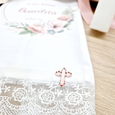 Toalha branca com renda floral e crucifixo rosa em cima