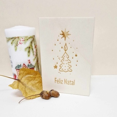 Cartão de Natal branco com árvore dourada e vela decorativa ao lado