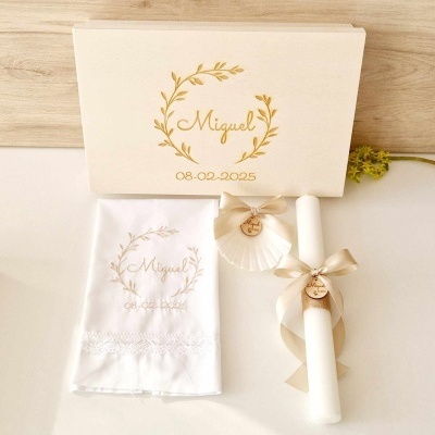 Conjunto de batizado com caixa de madeira personalizada, toalha branca bordada, vela com fita bege e medalha, e concha decorativa.