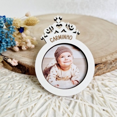 Moldura redonda branca com coroa e foto de bebé sorridente