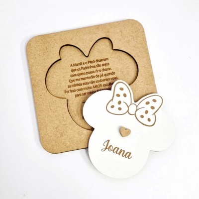 Convite em madeira branca com laço e nome Joana, acompanhado de base de madeira com texto gravado.