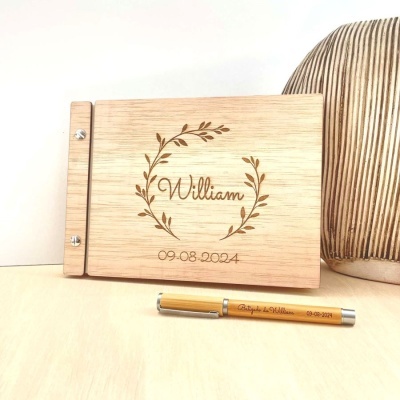 Livro de madeira gravado com nome William e data 09·08·2024 ao lado de caneta personalizada