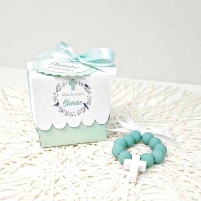 Caixa de oferta com pulseira de contas verdes e cruz branca