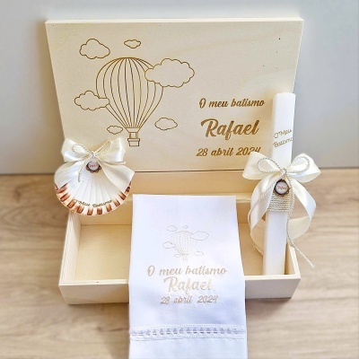 Caixa de madeira decorativa com itens para batismo em tons brancos e bege.