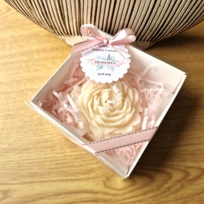 Caixa com vela em forma de flor creme e laço rosa, com etiqueta de lembrança.