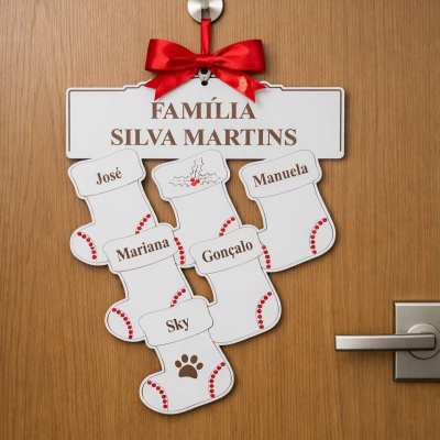 Placa decorativa branca com laço vermelho e meias de Natal personalizadas com nomes penduradas numa porta de madeira.