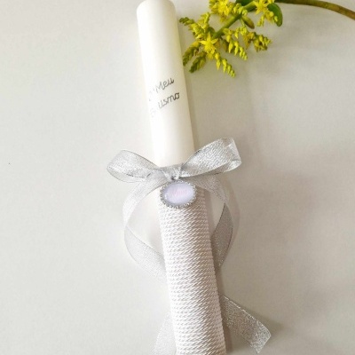 Vela branca decorada com fita prateada e flor amarela
