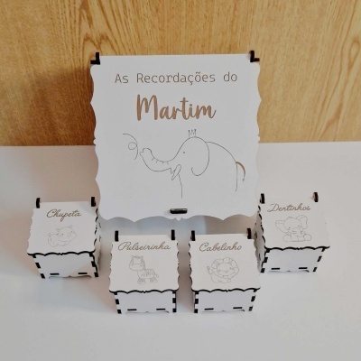 Caixas de recordações brancas com texto e desenhos de elefante, chupeta, pulseirinha, cabelinho e dentinhos