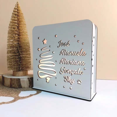 Suporte decorativo em madeira branca com nomes gravados e desenho de árvore de Natal
