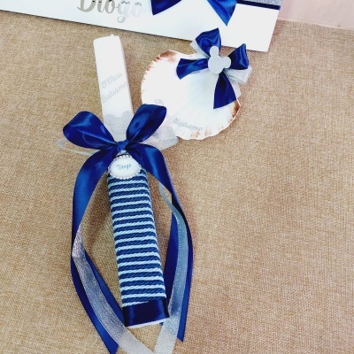 Vela decorativa azul e branca com coração de cerâmica azul e branco sobre tecido bege