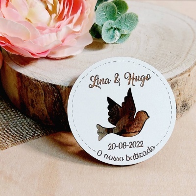 Etiqueta redonda branca com recorte de pomba de madeira e texto gravado à volta