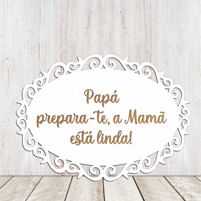 Placa oval decorativa branca com texto em castanho sobre fundo de madeira clara