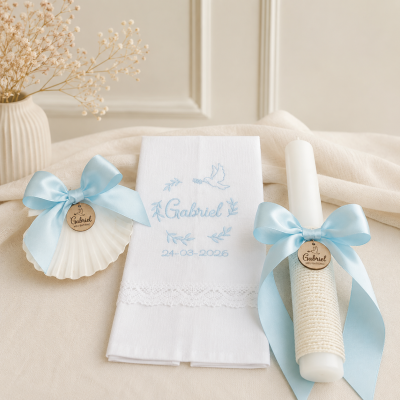 Conjunto decorativo para batismo com vela, concha e toalha, tudo em branco e azul claro.