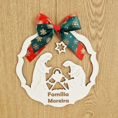 Enfeite natalício em madeira com recorte da Sagrada Família e laço colorido com flocos de neve