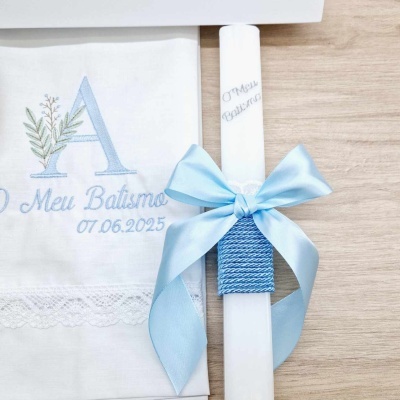 Vela branca decorativa com laço azul e toalha branca bordada para batismo