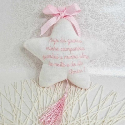 Estrela decorativa branca em tecido com bordado rosa e laço rosa