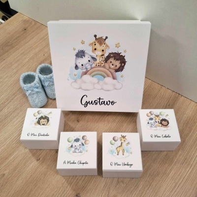 Caixas brancas decoradas para lembranças de nascimento com tema de animais e sapatinhos azuis ao lado
