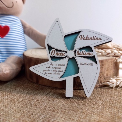 Decoração de madeira branca em forma de moinho de vento com texto relacionado a batismo.