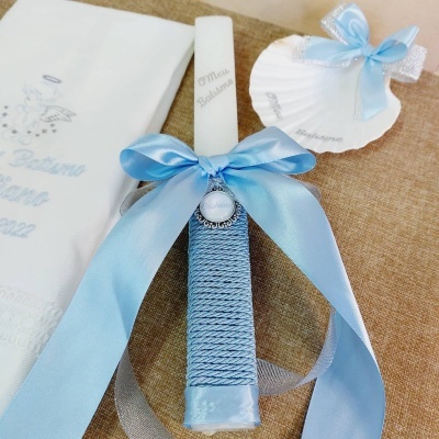 Vela decorativa de batismo branca com detalhes azuis e concha decorativa.