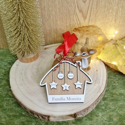 Enfeite de madeira em forma de casinha com nomes e fita vermelha