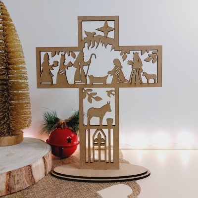 Cruz decorativa de madeira com cena da natividade recortada