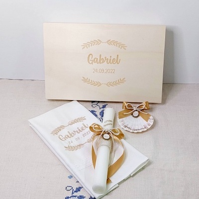 Conjunto de batismo com caixa de madeira, toalha branca, vela decorada e acessório com fita dourada
