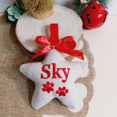 Decoração natalícia em forma de estrela branca com texto Sky e pegadas vermelhas