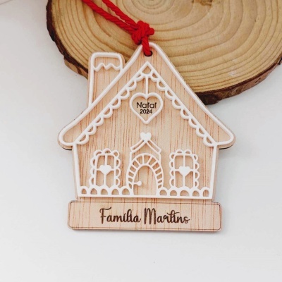 Enfeite de madeira em forma de casa com cordão vermelho e inscrições Natal 2024 e Familia Martino