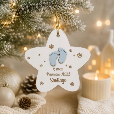 Estrela de madeira branca com pegadas de bebé azul e texto gravado pendurada em árvore de Natal
