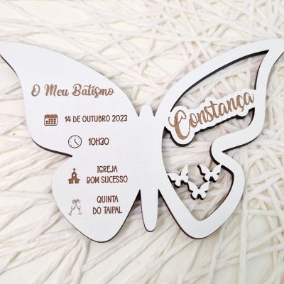 Convite de batismo em formato de borboleta branco com texto gravado castanho sobre fundo branco de tecido