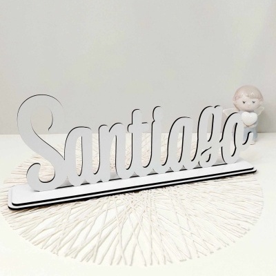 Objeto decorativo em madeira branca com a palavra Santiago em letra cursiva numa base