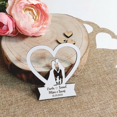 Figura decorativa de coração com casal e criança em madeira branca e texto gravado sobre tecido rústico