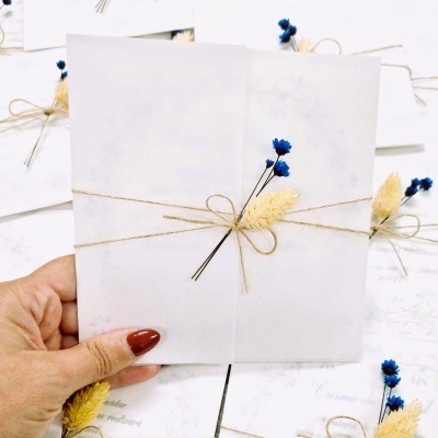 Envelope branco decorado com flores secas e amarrado com fio rústico