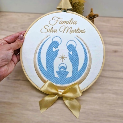 Bordado em bastidor com frase Família Silva Martins e laço dourado