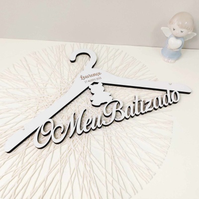 Cabide branco de madeira com texto recortado O Meu Batizado e figura de anjo