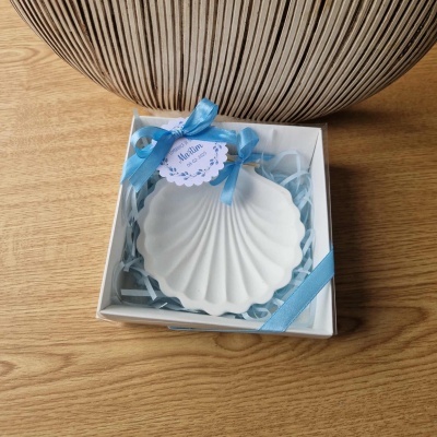 Prato concha branco em caixa com fita azul e cartão na madeira