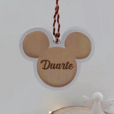 Placa de madeira em forma de cabeça do Mickey Mouse com o nome Duarte gravado, pendurada por corda vermelha e dourada.