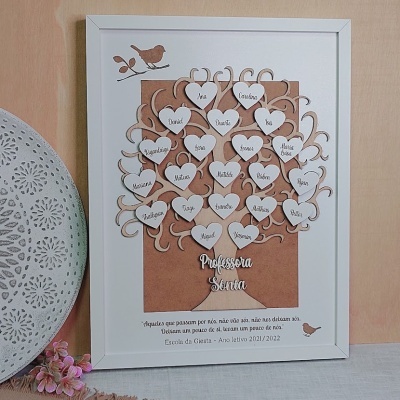 Moldura branca com árvore decorativa de madeira e corações com nomes, texto 