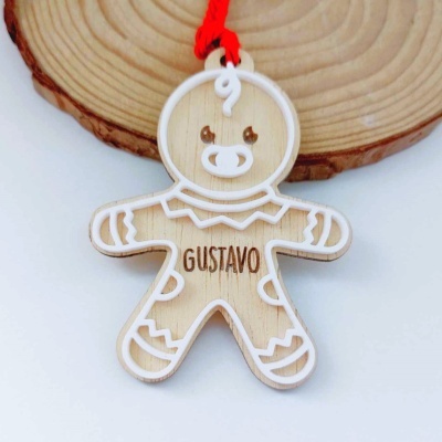 Ornamento de homem de gengibre em madeira com nome 'GUSTAVO' gravado, com fio vermelho para pendurar.